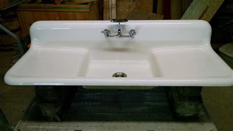 There is some wear to the inside of the bowl and a few small chips. . Vintage cast iron sink with drain board